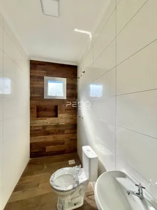 Hall de banheiro com revestimento de madeira e piso de madeira.