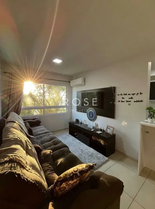 Sala de estar com sofá e janela iluminada.