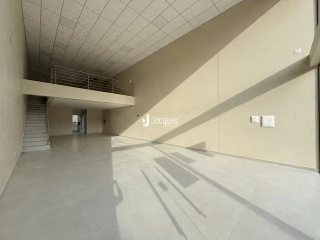 Corredor amplo com teto de grid e escadaria em um imóvel em Lajeado.