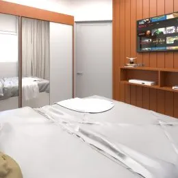 Foto de um quarto com cama de casal e roupa de cama branca.