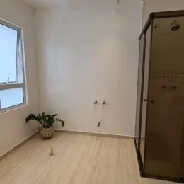 Ambiente interno com piso de madeira clara e janela na sala.
