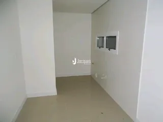 Corredor interno de uma residência com paredes brancas e piso claro.