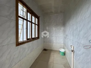 Corredor interno com paredes de azulejo e janela.