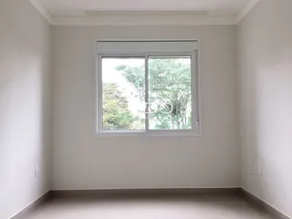 Quarto interno com parede branca e janela.