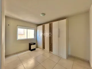 Interior de um ambiente com piso de cerâmica e armários embutidos.