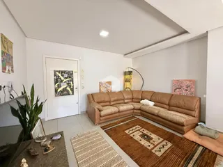 Sala de estar com sofá grande e tapete em um imóvel em Lajeado.