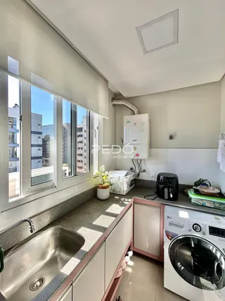 Vista da cozinha com bancada e janela em um imóvel no Brasil.