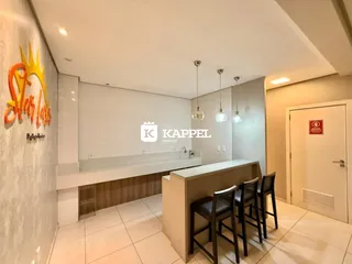 Esta é uma cozinha moderna com bancada longa e banquetas de madeira.
