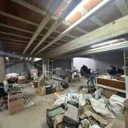 Foto de um espaço interno em construção com estrutura de teto exposta.