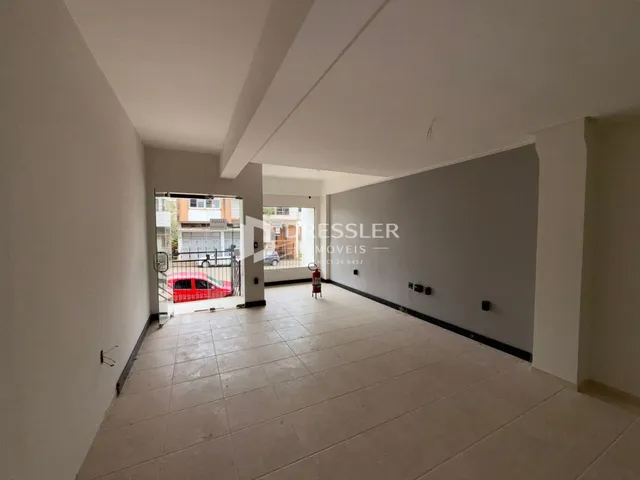 Hall de entrada com piso de cerâmica claro e paredes brancas.