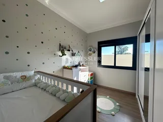 Quarto com cama de madeira e decoração de parede clara.