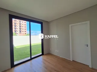Sala com grande janela que oferece vista para um gramado verde.