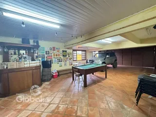 Ambiente interno amplo com piso de cerâmica e móveis de madeira.
