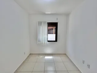 Interior de uma sala com paredes brancas e piso de cerâmica.