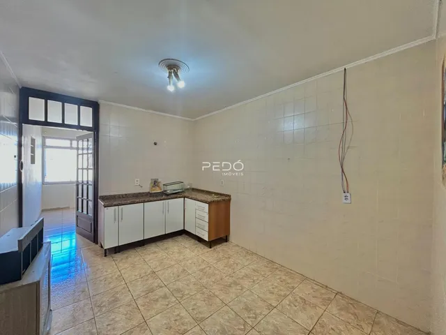 Interior de uma sala de estar com cozinha em um imóvel.