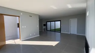 Ambiente interno moderno com piso de porcelanato e grandes janelas que dão vista para o exterior.