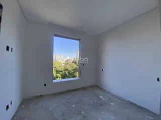 Foto de um cômodo vazio com parede branca e piso de concreto.