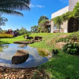 Vista externa de um terreno com grama e rochas.