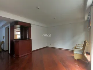 Sala de estar com piso de madeira polida e móvel de madeira.