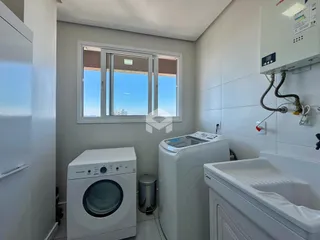 Interior de um banheiro com máquina de lavar e banheira.