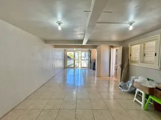 Hall de entrada com piso de cerâmica e portas.