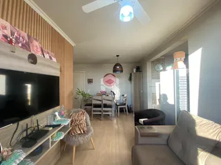 Sala de estar com televisão e área de jantar em um imóvel no Brasil.
