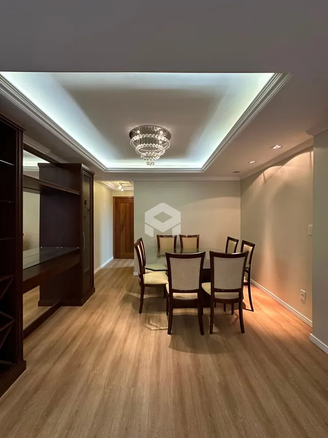 Sala de estar com piso de madeira e decoração de teto.
