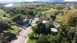 Vista aérea de uma propriedade rural com vegetação densa e estrada.