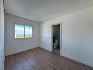 Ambiente interno com piso de madeira e janela.
