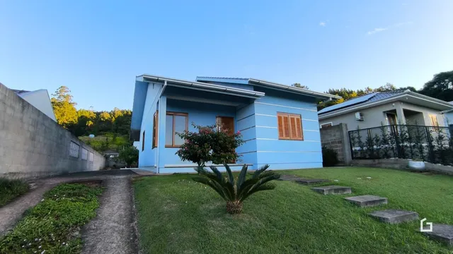 Fachada de uma casa azul com jardim em Lajeado.