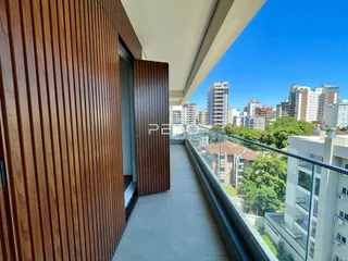 Vista de uma varanda com vista para a cidade e vegetação.