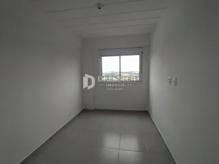 Vista interna de um corredor com piso de cerâmica claro e janela.