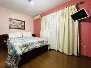 Quarto com cama e cortinas em uma sala de Lajeado, Brasil.