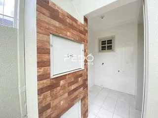 Vista interna de um corredor com parede texturizada e piso de cerâmica.