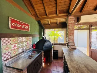 Interior de uma cozinha rústica com detalhes em tijolo e madeira.