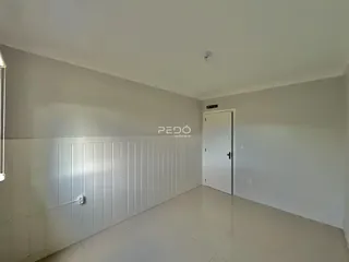 Hall de corredor interno com paredes brancas e piso claro.