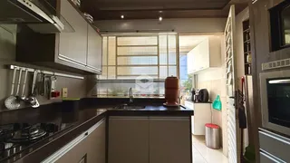Vista da cozinha com armários de madeira e bancadas escuras.