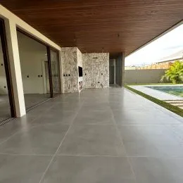 Hall de entrada com piso de concreto polido e parede texturizada.