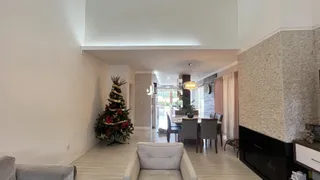 A sala de estar apresenta paredes brancas e piso de madeira clara.