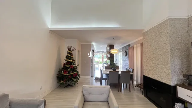A sala de estar apresenta paredes brancas e piso de madeira clara.
