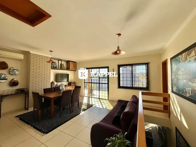 Sala de estar com mesa de jantar e sofá em um ambiente claro.