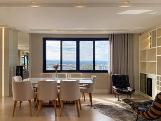Sala de jantar com mesa branca e vista panorâmica da cidade.
