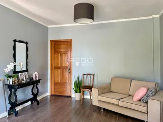 Sala de estar com sofá e porta de madeira em um imóvel no Brasil.