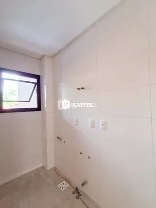 Foto de um corredor interno com parede branca e janela.