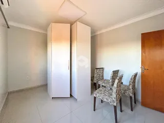 Quarto com armários e cadeiras em ambiente claro.