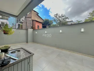 Vista de uma área externa com parede e piso de cerâmica.