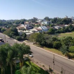 Vista externa de uma rua residencial com vegetação em Lajeado, Brasil.