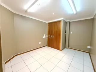 Imagem de um ambiente interno com piso de cerâmica branca e paredes neutras.