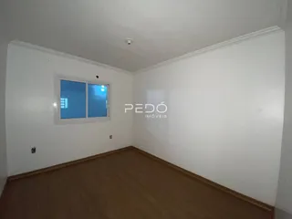 Ambiente interno de uma sala com piso de madeira e janela.