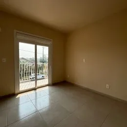 Sala com porta de vidro que dá acesso a uma área externa.